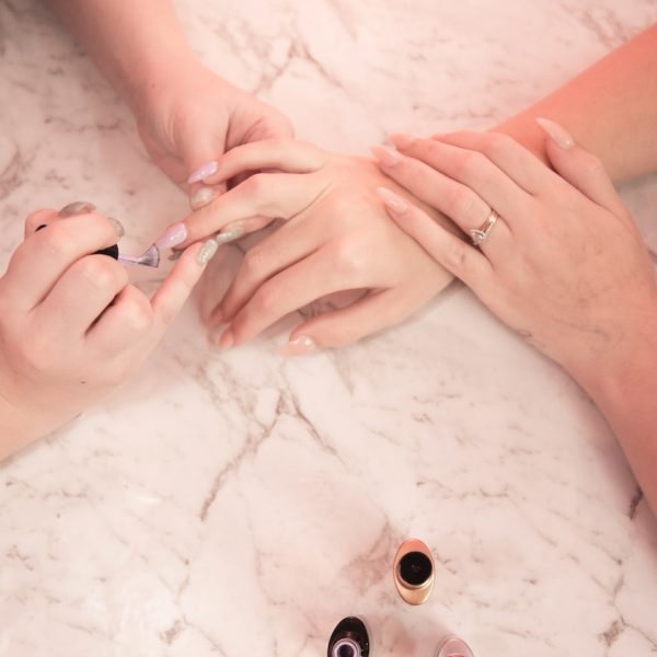 person holding silver ring on white textile